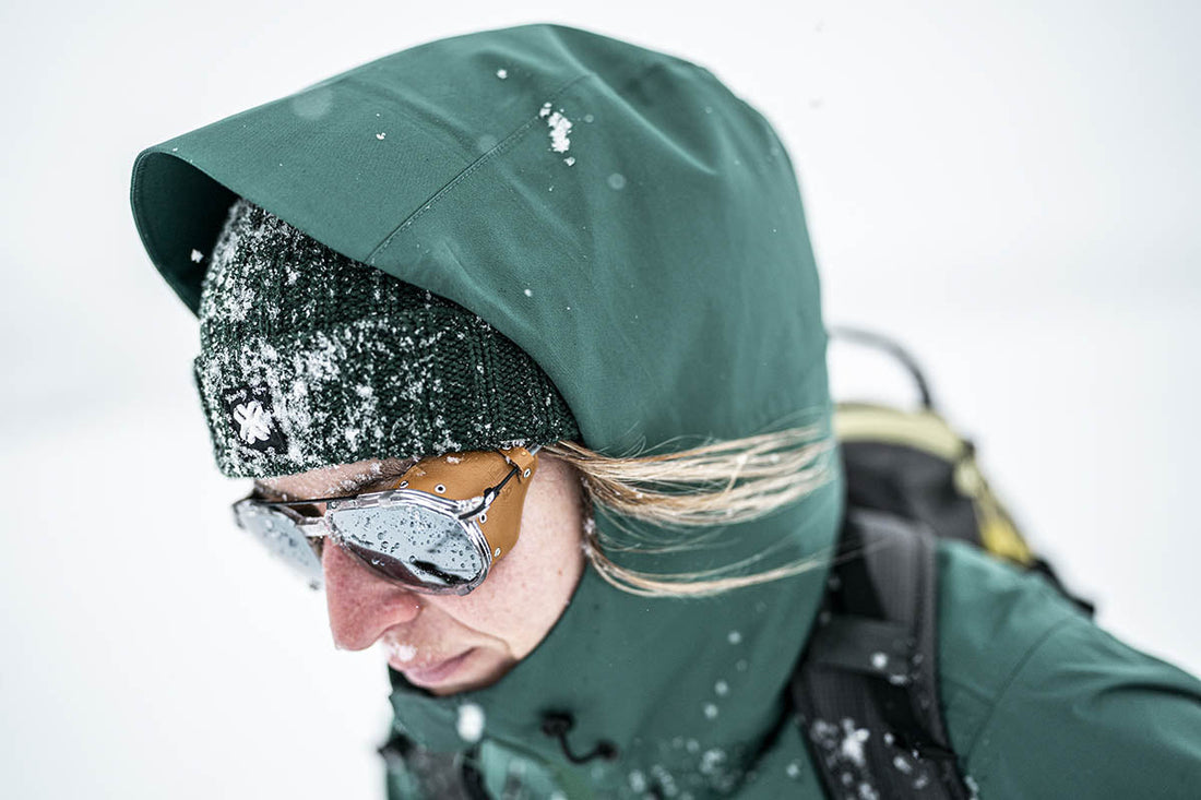 Personne portant une veste verte à capuche dans la neige