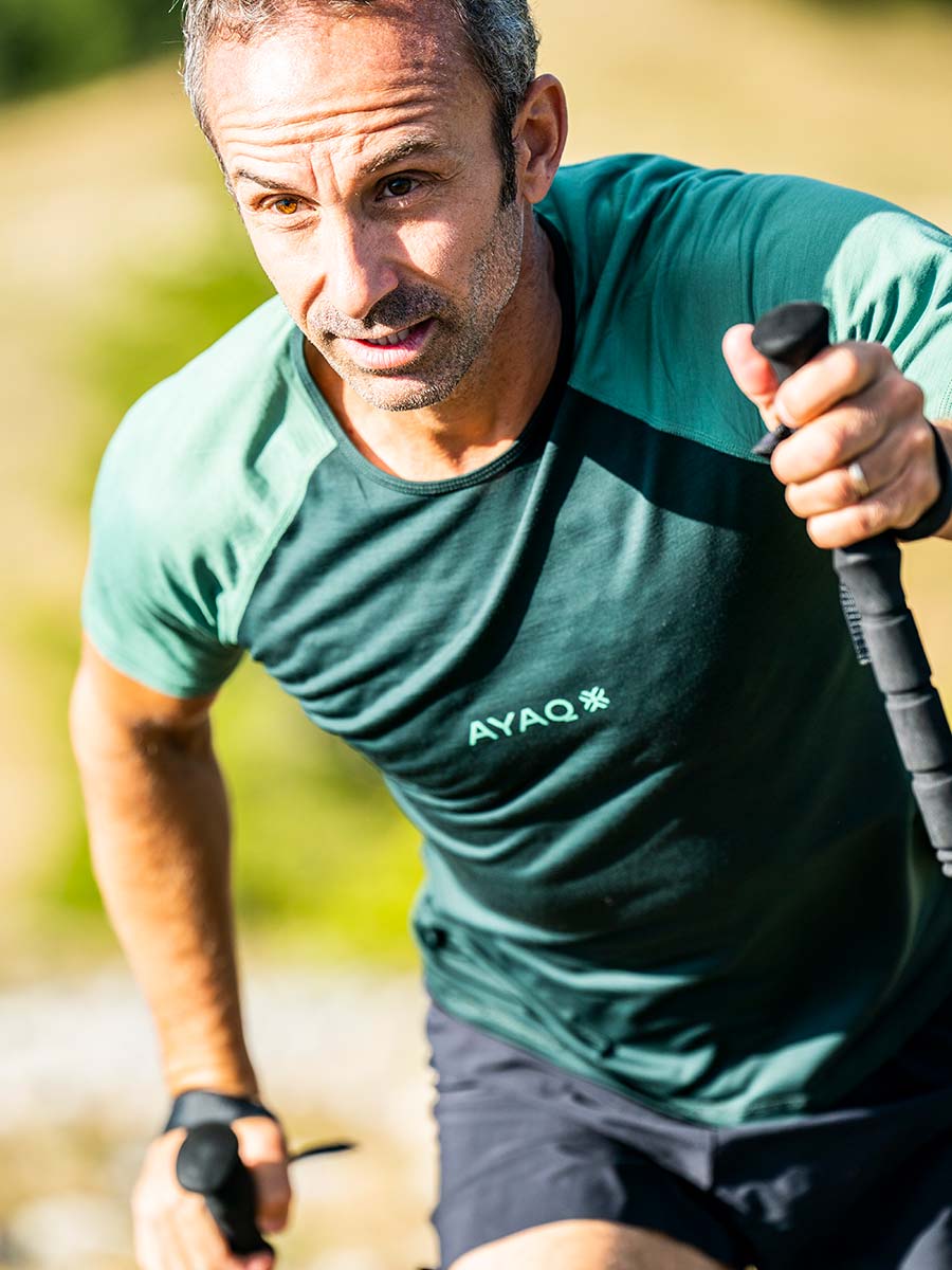 Personne en t-shirt vert progressant avec des bâtons