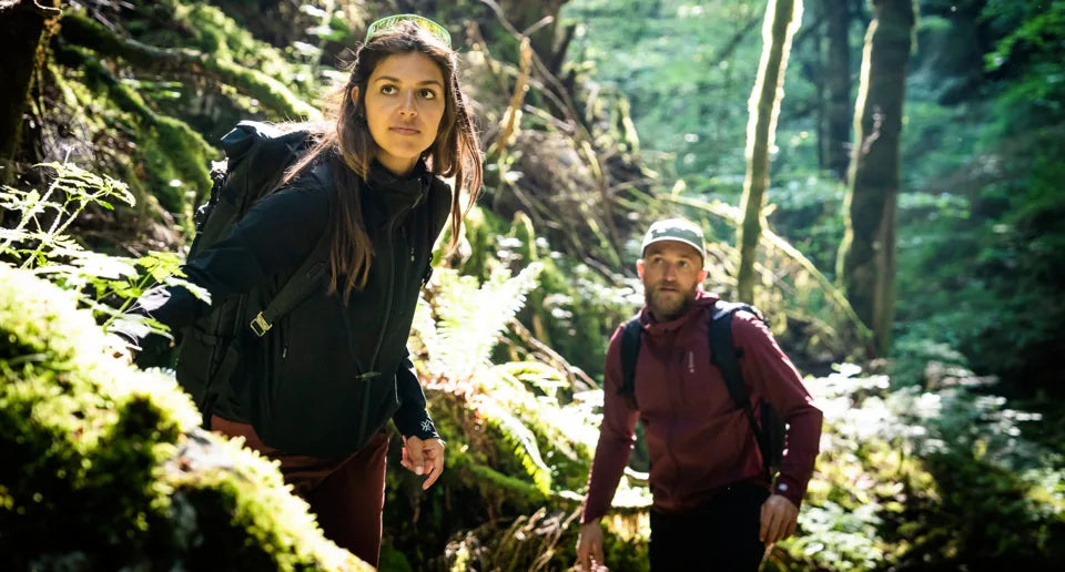 Deux randonneurs équipés AYAQ marchant en forêt avec leurs sacs